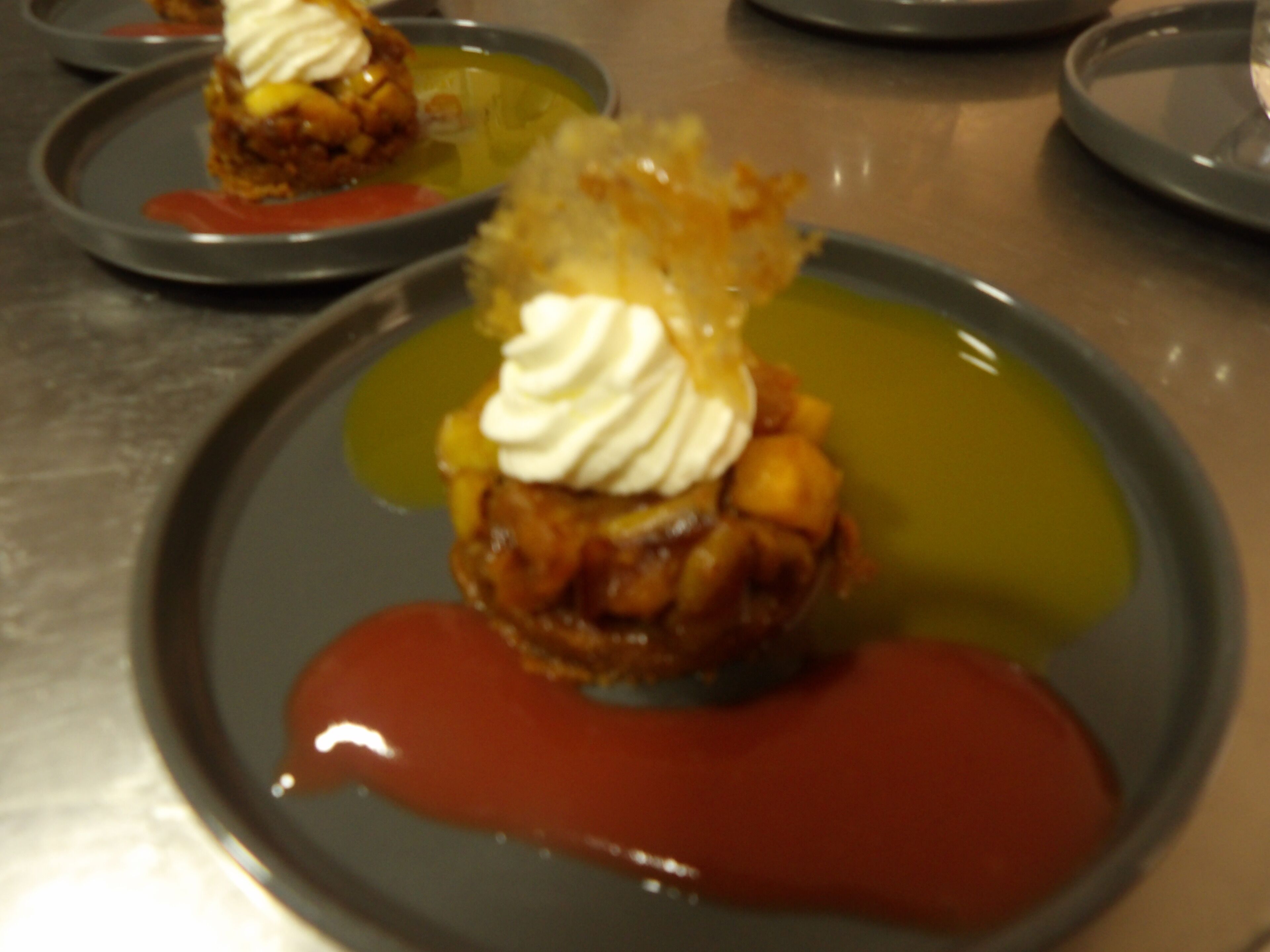 Un postre con crema batida y salsa de caramelo sobre un plato.
