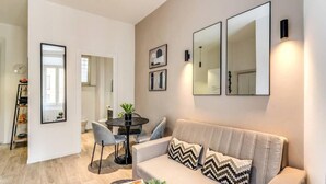 Un salon moderne comprenant un canapé, une table basse et un coin repas avec une table et des chaises.