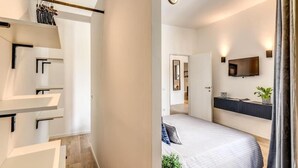 Une chambre à coucher moderne avec un lit, une télévision et une petite plante.