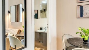 Une pièce moderne comprenant un coin repas, un canapé, une table et une plante.