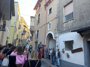 Una calle estrecha flanqueada por edificios, algunos con balcones y otros con ventanales a nivel de calle.