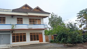 A two-story residential building with a balcony, a garage, and a gated entrance. - Hotel O Wisma Deli Syariah Near RSUD Nene Mallomo Sidenreng Rappang (Pangkajene)