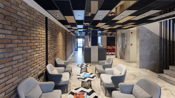 A modern lounge area with brick walls, seating, and a checkered ceiling pattern. - Ahg Atlas Hotel Taksim (Istanbul)