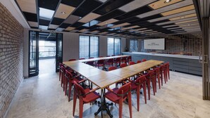 A conference room with a long wooden table and red chairs, a brick wall, and a modern ceiling design. - Ahg Atlas Hotel Taksim (Istanbul)