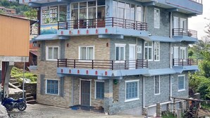 Un immeuble à plusieurs étages doté de balcons, de fenêtres et d’une enseigne.