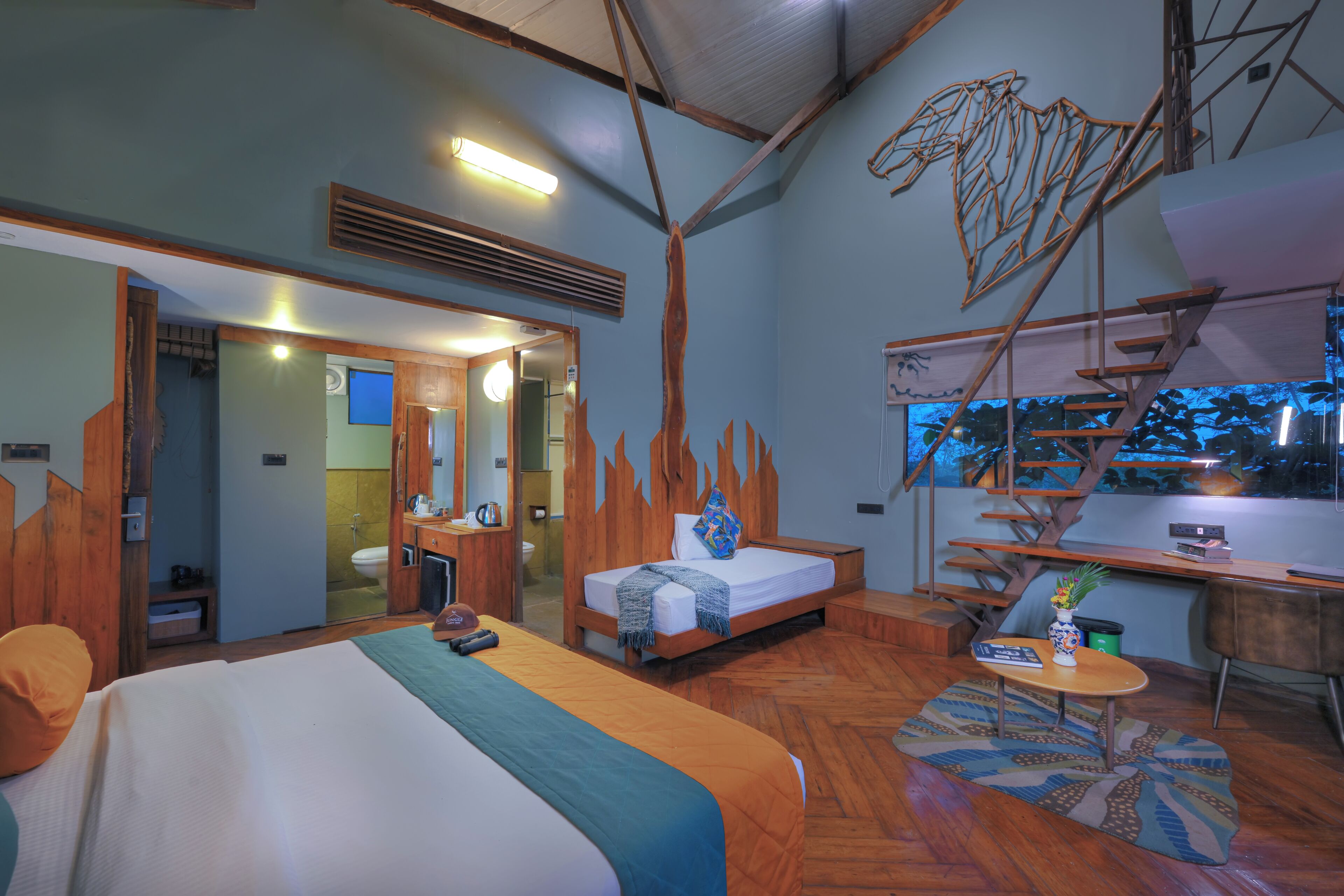 A room with a bed, a desk, a chair, and a staircase.