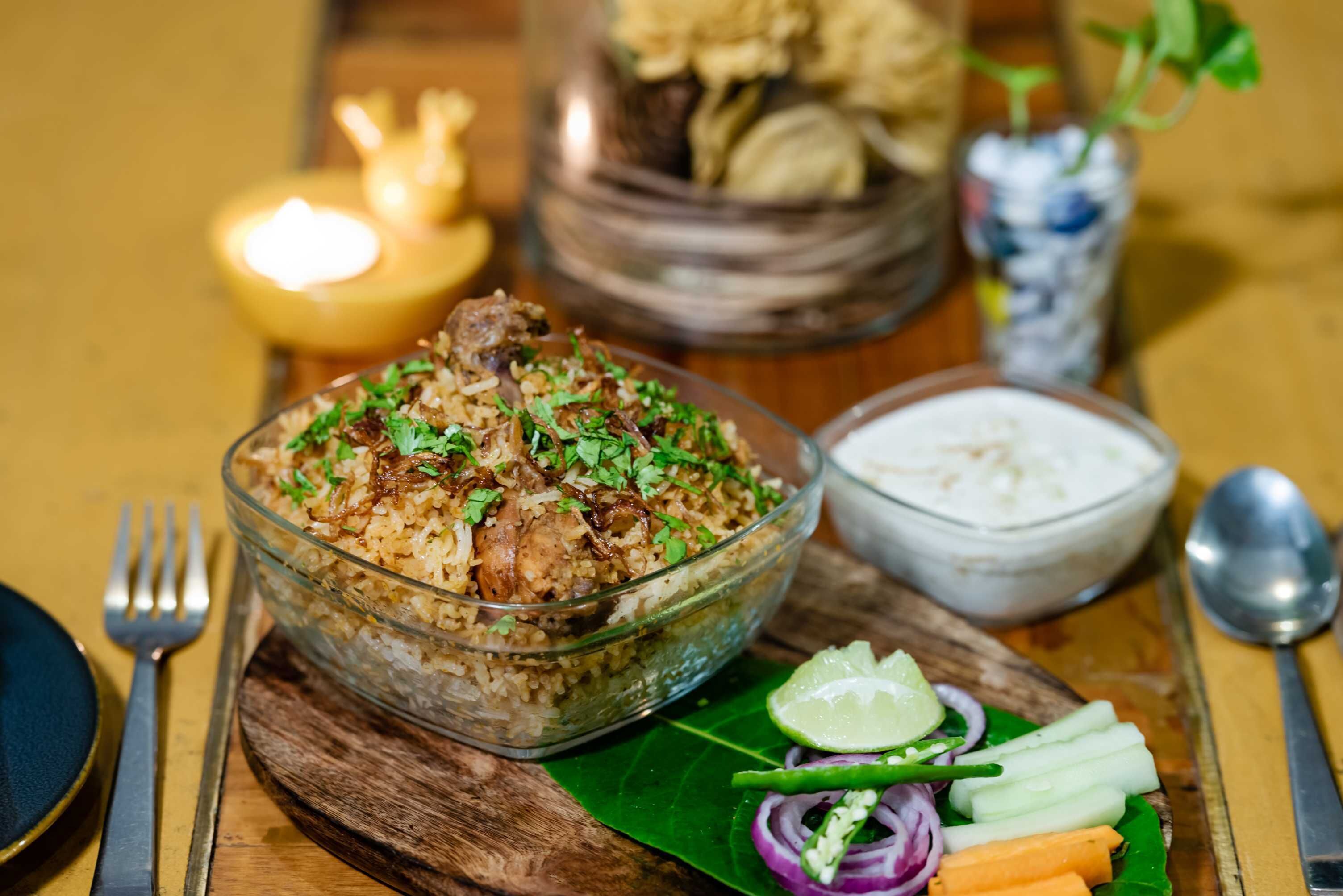 A meal with rice, meat, and vegetables, accompanied by a bowl of sauce and a lime wedge.