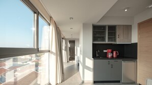 A modern kitchen with a view to the outside, a small refrigerator, and a coffee maker. - Sky-High Central Penthouse - 01 (Chania)