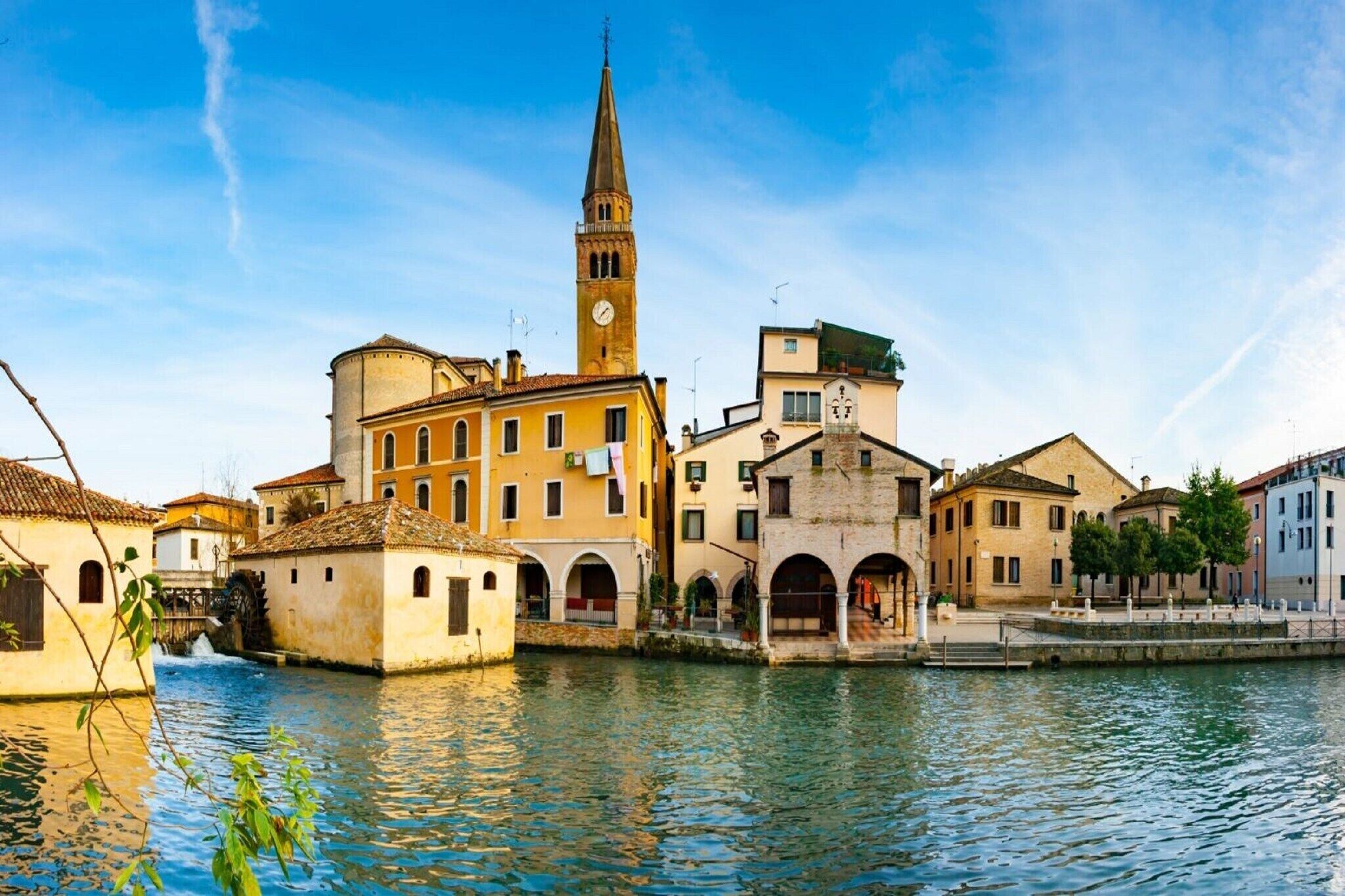 A historic waterfront area with buildings, a prominent tower, and a waterway.