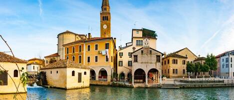 A historic waterfront area with buildings, a prominent tower, and a waterway.