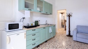 Eine Küche mit Mikrowelle, Kühlschrank und Schränken.