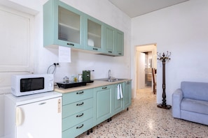 A kitchen with a microwave, refrigerator, and cabinets.