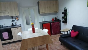 Una cocina compacta con una mesa de comedor, un sofá y una pequeña mesita auxiliar.