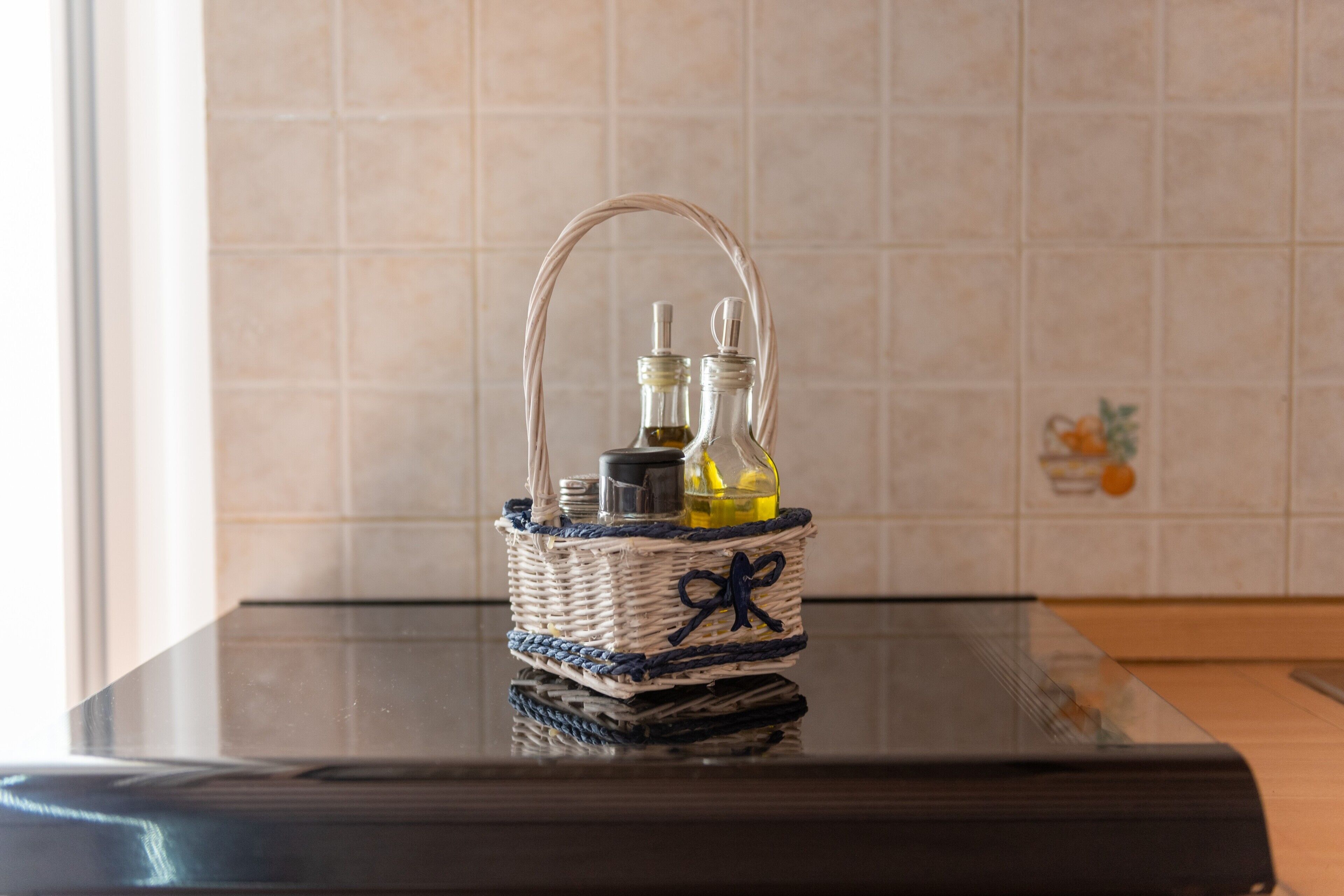 A woven basket with a handle on a reflective surface.