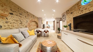 A modern living room with a sofa, coffee table, and dining area. - Apartment 'Plaisir Des Pierres' with Private Terrace and Wi-Fi (RIVESALTES)