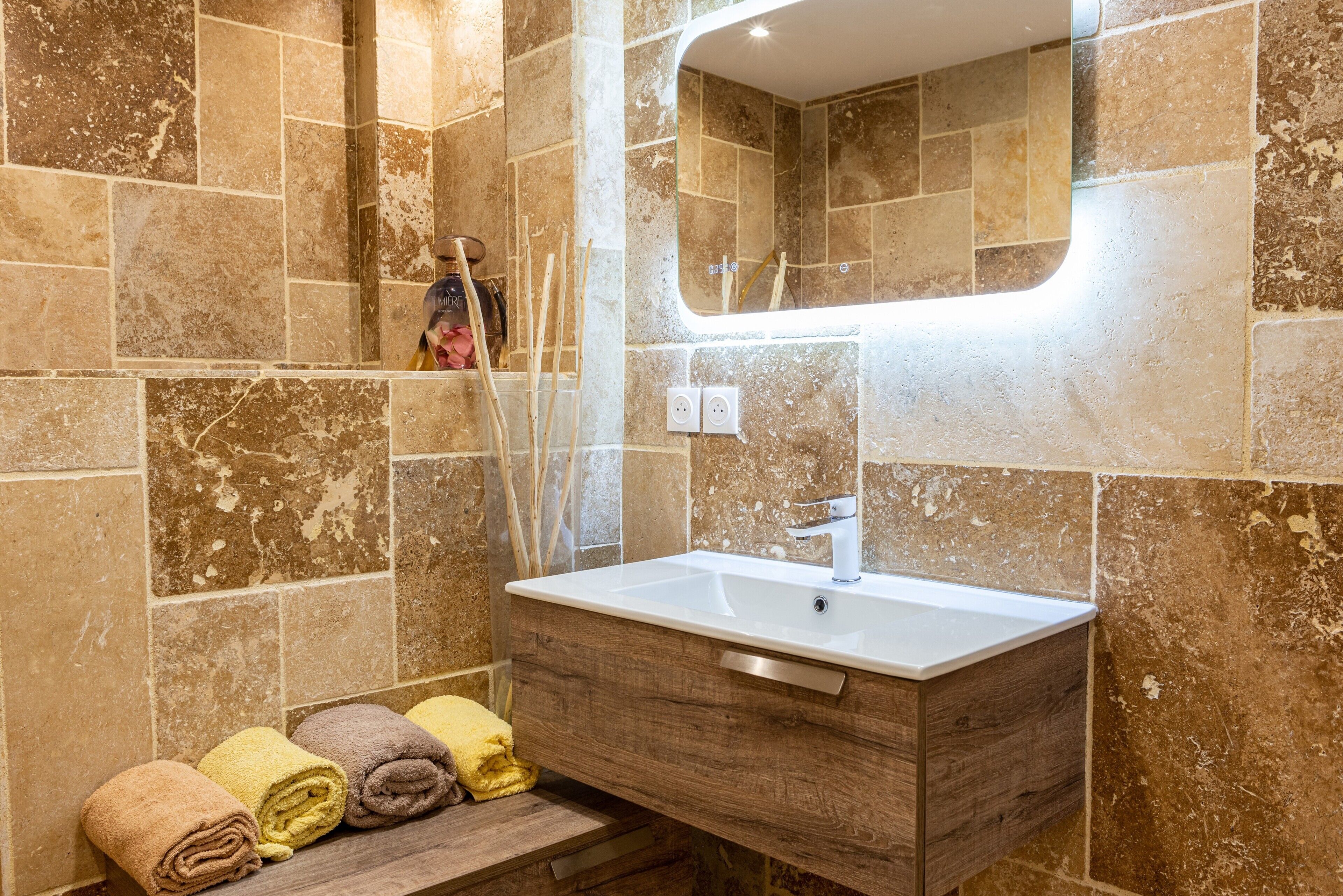 A bathroom with a sink, mirror, and towel rack.