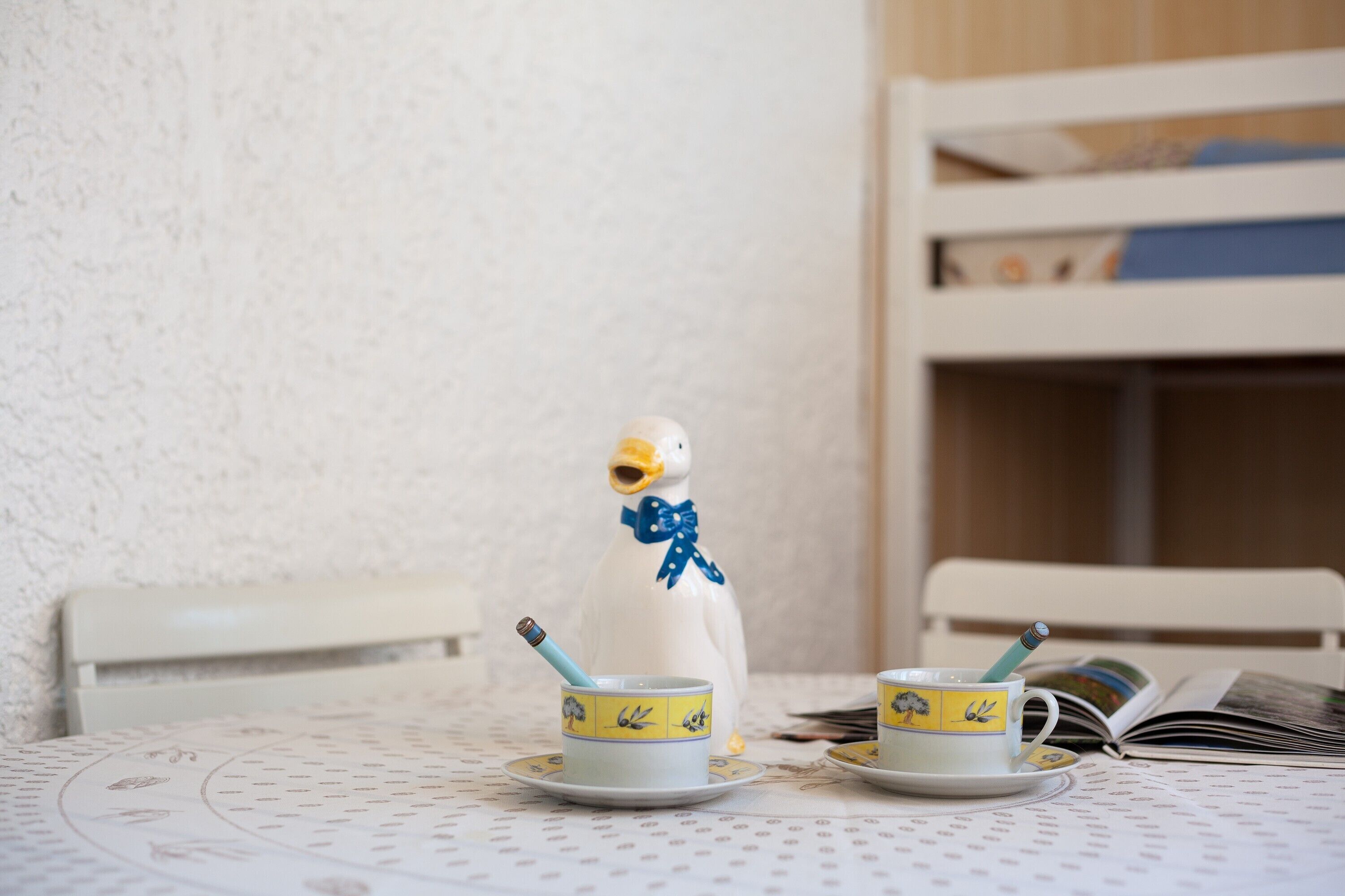A table with two cups and a duck figurine.