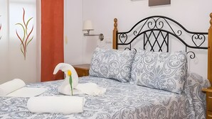 A neatly made bed with patterned bedding, a decorative swan, and a wall with abstract art. - 'Bahía D'Or Plaza' Apartment with Air Conditioning (Chiclana de la Frontera)