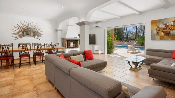 A spacious living area with a fireplace, modern furniture, and a view of the outdoors.