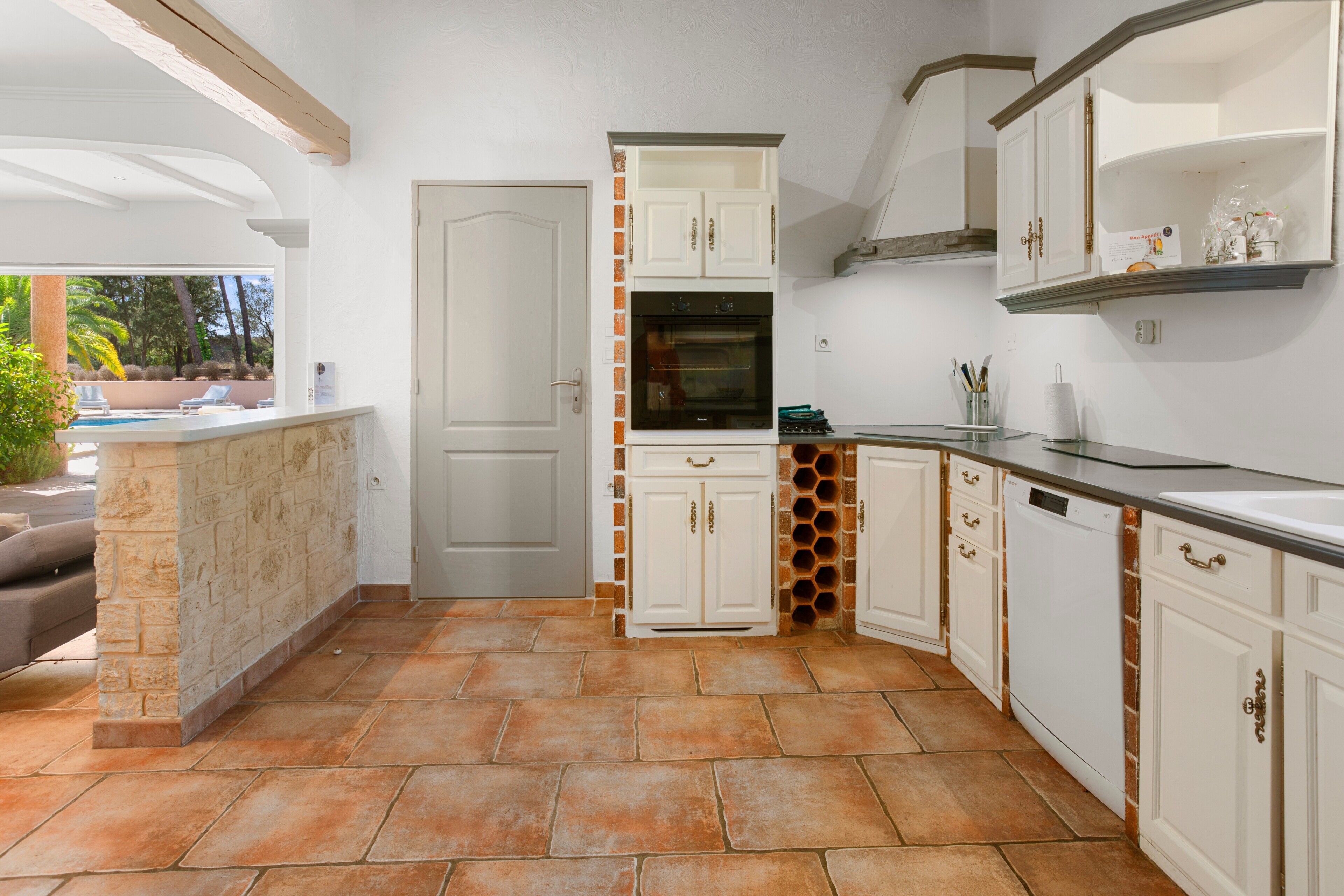A kitchen with white cabinets, a built-in oven, and a countertop.