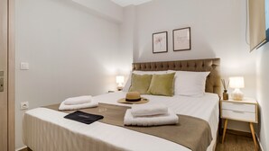 A neatly arranged bedroom with a bed, bedside tables, and wall art. - Apartment 'Ionian Sea View Luxury Apartments' with Wi-Fi and Air Conditioning (Lefkada)