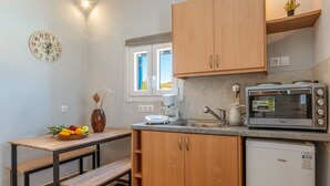 Eine kleine Küche mit Kaffeemaschine, Toaster und kleinem Kühlschrank.