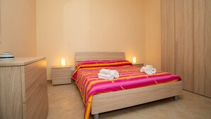 Une chambre à coucher avec un lit, des tables de chevet et une armoire.