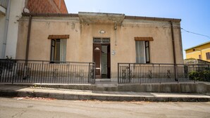 Un immeuble à la façade beige, à la porte marron et doté d’un petit balcon.