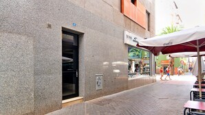 A street with a building featuring a storefront with a Coca-Cola umbrella, a visible fire hydrant, and a sidewalk. - Vacation Home "Laura y Juan" with Sea View & Wi-Fi (Las Palmas de Gran canaria)