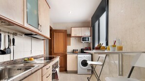 A compact kitchen with a washing machine, a microwave, and a sink. - Vacation Home "Laura y Juan" with Sea View & Wi-Fi (Las Palmas de Gran canaria)