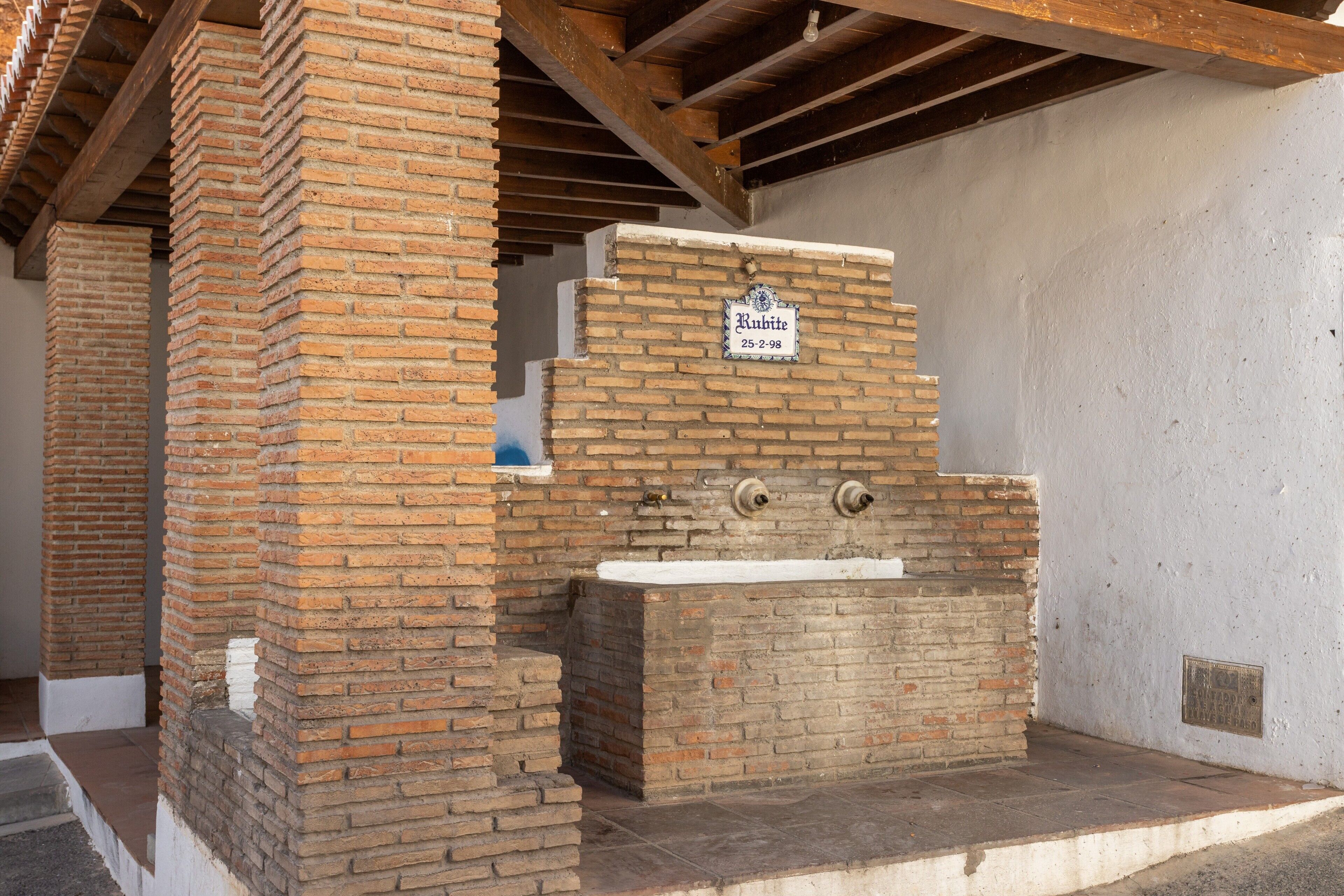 Una estructura de ladrillo con un letrero que dice 'Rubite 25-2-98' y una bañera.