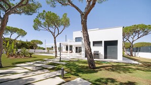 A modern house with a patio, a swimming pool, and a garden with trees. - "Alba Sea" Villa with Private Pool, 2 Private Terraces and Wi-Fi (Chiclana de la Frontera)