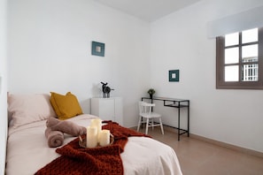 Une chambre à coucher avec un lit, un bureau, une chaise et une fenêtre.