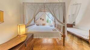 A bedroom with a four-poster bed, a wooden dresser, a bedside table with a lamp, and a small window. - Villa 'Blu La Patronale' with Sea View, Shared Pool and Wi-Fi (Castro)