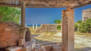 Ancient ruins with stone walls and columns, a brick structure, and a view of the sea. - Platanias Beachfront Villa Elsa-90m To Main Square (Platanias)