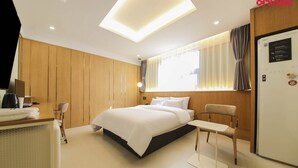 A modern hotel room with a large bed, a desk with a computer, and a seating area. - No.25 Hotel (Gwangju)