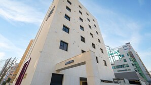 A tall building with a 'PARKING' sign, multiple windows, and a clear sky. - No.25 Hotel (Gwangju)