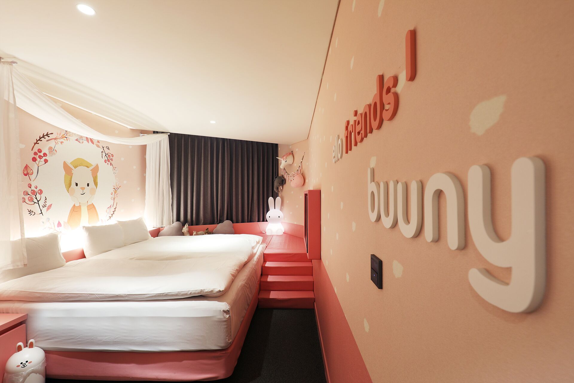 Una habitación de hotel moderna con una cama grande, un sofá pequeño y una escalera que lleva a un nivel superior.