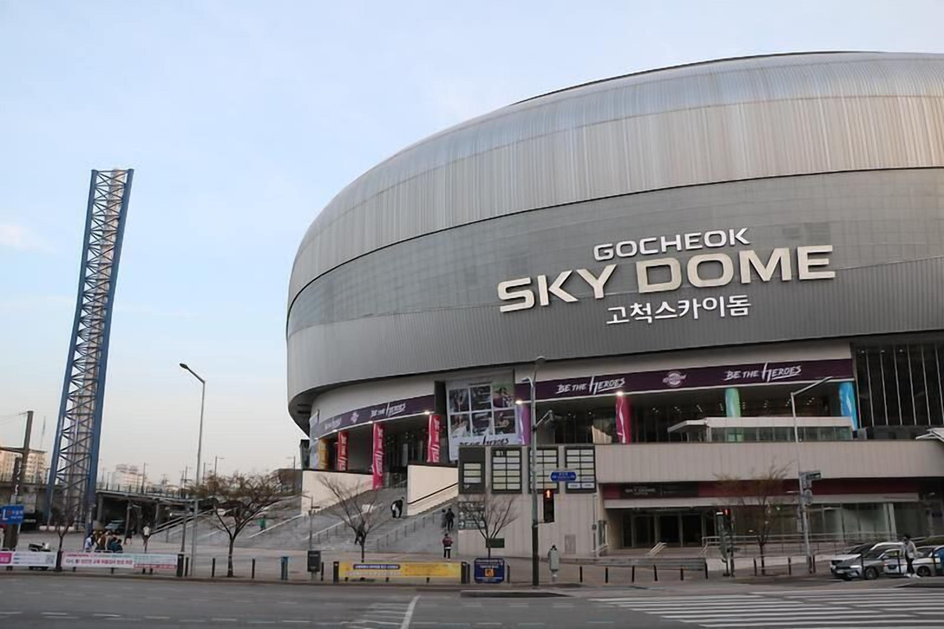 A large, modern building with the sign "Gocheok Sky Dome" and "Be the Heroes" banners.