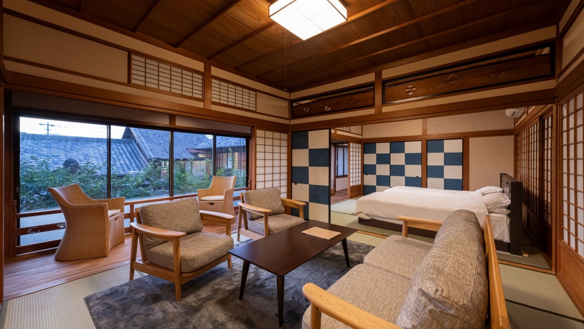 A traditional Japanese-style room with tatami flooring, a low ceiling, and sliding doors.
