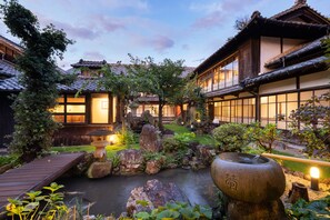 En traditionel japansk gårdsplads med en dam af koi-karper, trægangstier og stenenlanterner.