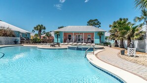 A swimming pool with lounge chairs and a building in the background. - 6007 Rookery 3 Just Breathe (Gulf Shores)