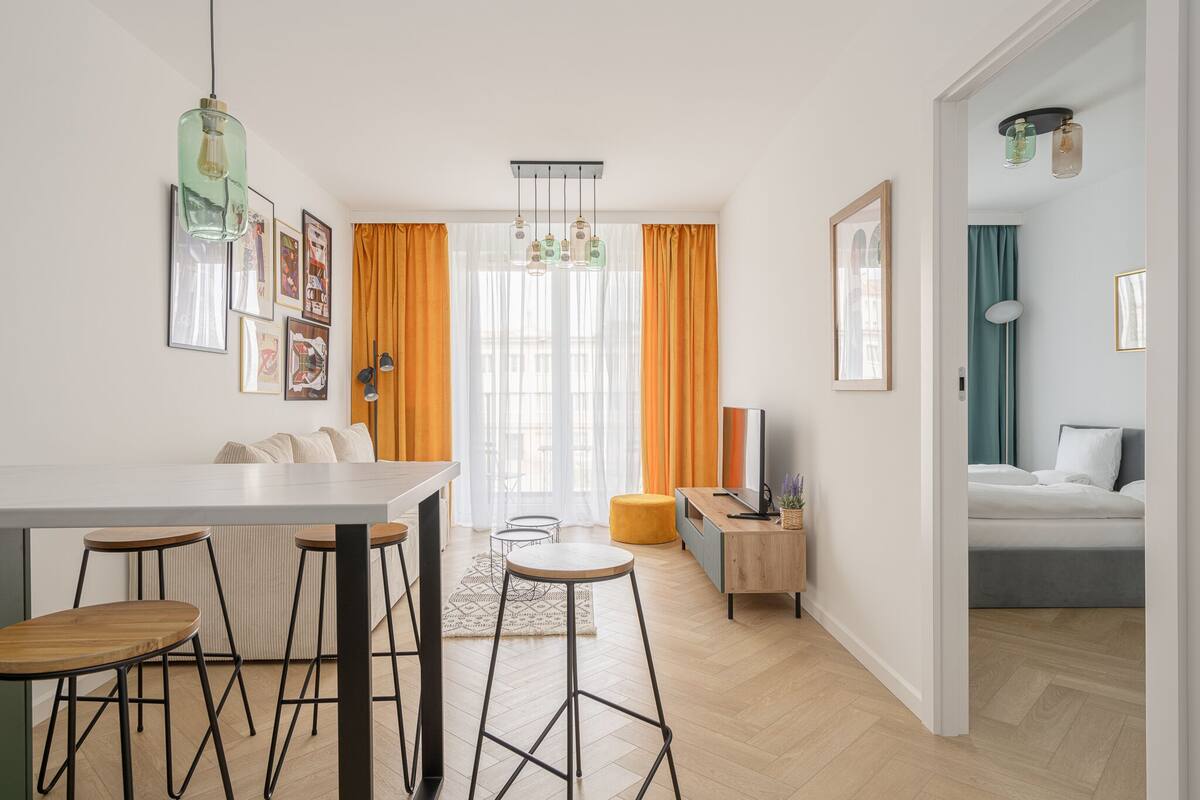 A modern living space with a dining area, kitchen, and bedroom.