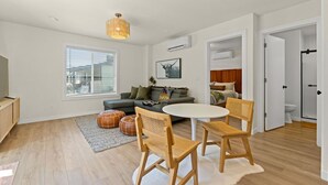 A modern living room with a sofa, two chairs, a round table, and a window with blinds. - Modern Guest House Near Downtown! (Washougal)