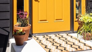 A yellow door with a window, a mailbox, and a doormat. - Modern Guest House Near Downtown! (Washougal)