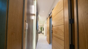 A hallway with wooden doors and a tiled floor. - Majestic & Spacious1b Downton Gym Pool (Santo Domingo)