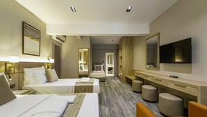 Une chambre d’hôtel avec deux lits, une télévision, un bureau et un miroir.