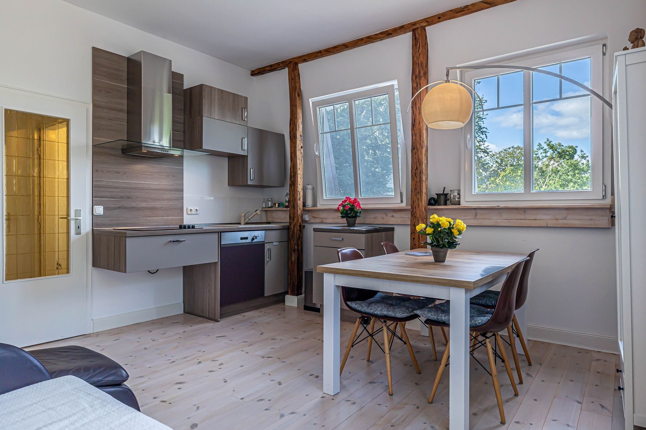 Una cocina moderna con armarios de madera, horno empotrado y una ventana sobre el fregadero.