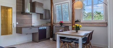 Una cocina moderna con armarios de madera, horno empotrado y una ventana sobre el fregadero.