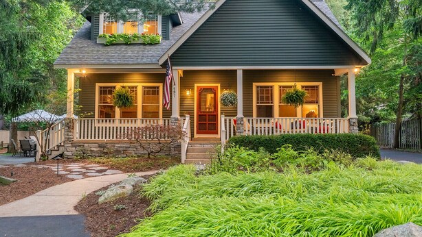 A two-story house with a front porch, stone steps, and a mailbox. - Your Michigan Cottage Awaits! (Douglas)